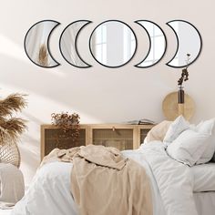 a bedroom with four mirrors hanging on the wall