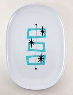 a white plate with blue and black designs on the side, in front of a white background