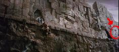 a man climbing up the side of a stone wall