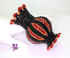 a black and red beaded bracelet on a white mannequin headdress