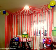 a room with red and white striped curtains on the wall, balloons in the air