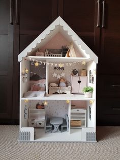 a doll house with furniture and accessories in the inside, on carpeted flooring