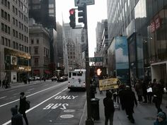 a busy city street with pedestrians and traffic lights