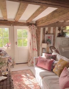 a living room filled with lots of furniture and pillows on top of a white couch