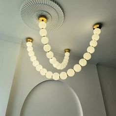 two lights are hanging from the ceiling in a room with white walls and flooring