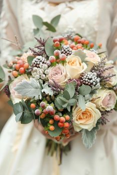 a bridal holding a bouquet of flowers and greenery