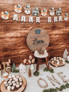 a dessert table with cupcakes, cookies and other treats on it at a woodland themed baby shower