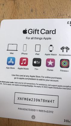 the gift card for all things apple is displayed on top of a wooden table with other items