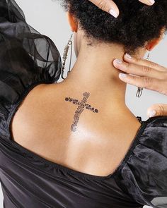 a woman with a cross tattoo on her back