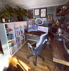 a computer desk sitting next to a book shelf filled with lots of books on top of a hard wood floor