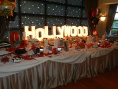 the hollywood sign is lit up with red and white streamers on it's table