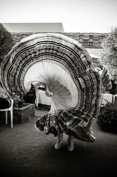 a woman is dancing in the middle of a courtyard