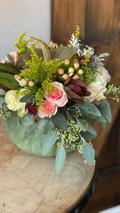 a vase filled with flowers sitting on top of a wooden table