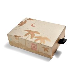 a cardboard box with palm trees and moon on the lid is open to show its contents