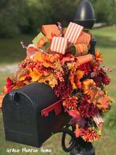 a mailbox decorated with fall foliage and bows