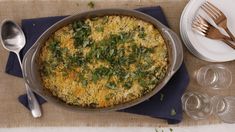 a casserole dish with spinach and cheese in it on a place mat next to silverware