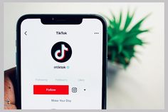someone is holding their cell phone with the tiktok app on it