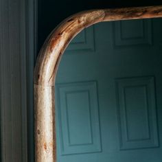 an old wooden mirror frame in front of a blue door