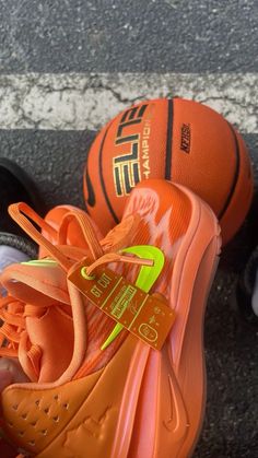 an orange nike shoe with a basketball on the ground