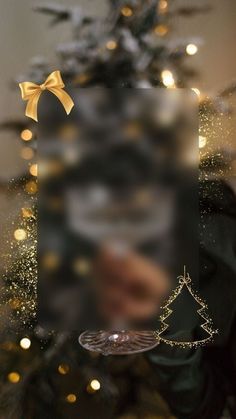 a christmas tree with lights in the background and a photo frame on it's side