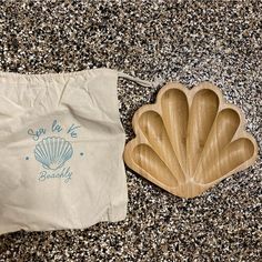 a wooden shell shaped dish next to a bag