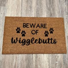 a door mat that says beware of wiggeburts on it with paw prints