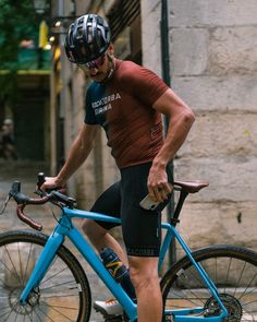 a man riding a blue bike down a street