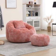 a living room with a pink chair and ottoman