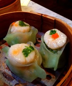 three dumplings are sitting in a wooden bowl