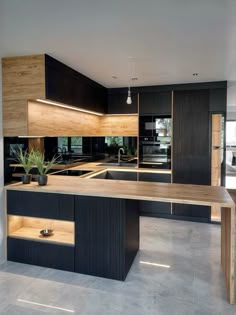 a modern kitchen with black cabinets and wooden counter tops, an island style sink and dishwasher