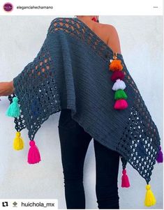 a woman is wearing a shawl with tassels on the sides and an open back