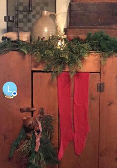 a christmas stocking hanging from the side of a wooden cabinet next to a vase