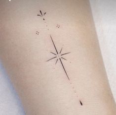 a small star tattoo on the left side of the arm, with tiny dots in it