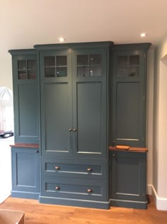 an empty room with blue cabinets and wood floors