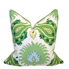 a green and white pillow on a white background