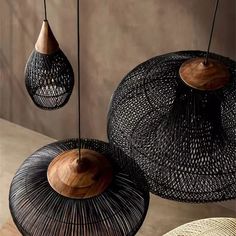 three black and white baskets hanging from hooks on the ceiling, one with wooden handles