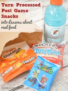 some snacks are sitting on a table next to a bottle of water and an orange bag