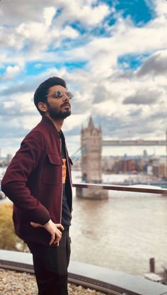 a man standing in front of the london skyline