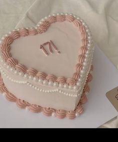 a heart shaped cake sitting on top of a table next to a card and knife