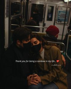 a man and woman sitting on a subway train with their faces covered by a mask