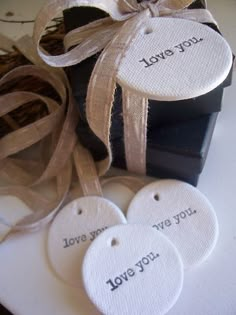 three tags that say i love you and two are tied to a black gift box