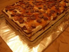 a cake that is sitting on some tin foil and covered in caramel toppings