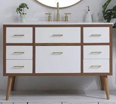 a white and brown cabinet with two faucets on the top is shown in front of a white background