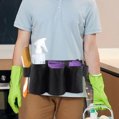 a man wearing green gloves and holding a bucket with cleaning products in it's pockets