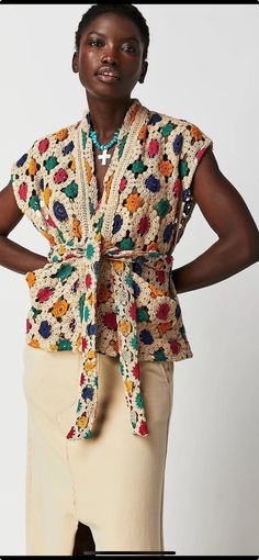 a woman is standing with her hands on her hips and wearing a colorful shirt over her shoulders