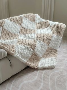 Cozy up with our handmade Checkered Chunky Knit Blanket. Featuring a soft, white and beige checker pattern, this blanket adds a touch of elegance and warmth to any room. Perfect for snuggling or as a stylish decor piece. Please note: Blankets are vacuum sealed to save you on shipping! Carefully open plastic with scissors when receiving your package. Blanket will return to its fullness within 20 minutes. -Dimensions: 50” x 60” -100% Chenille Polyester -This is a handmade item which means each blanket may vary slightly. -Care Instructions: Spot Clean or Machine Wash on Gentle/Cold Setting. Dry on Low Heat. Chunky Crochet Blanket, Easy Crochet Animals, Checker Pattern, Wall Decor Lights, Crochet Blanket Designs, Blanket Diy, Chunky Blanket, White And Beige, Chunky Knit Blanket