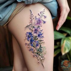 a woman's thigh with purple flowers on it