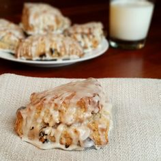 a close up of a pastry on a napkin with a glass of milk in the background