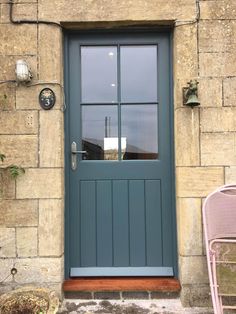 a blue front door with two pink chairs