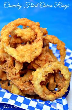 some fried onion rings are on a blue and white checkered plate with the words crunchy fried onion rings